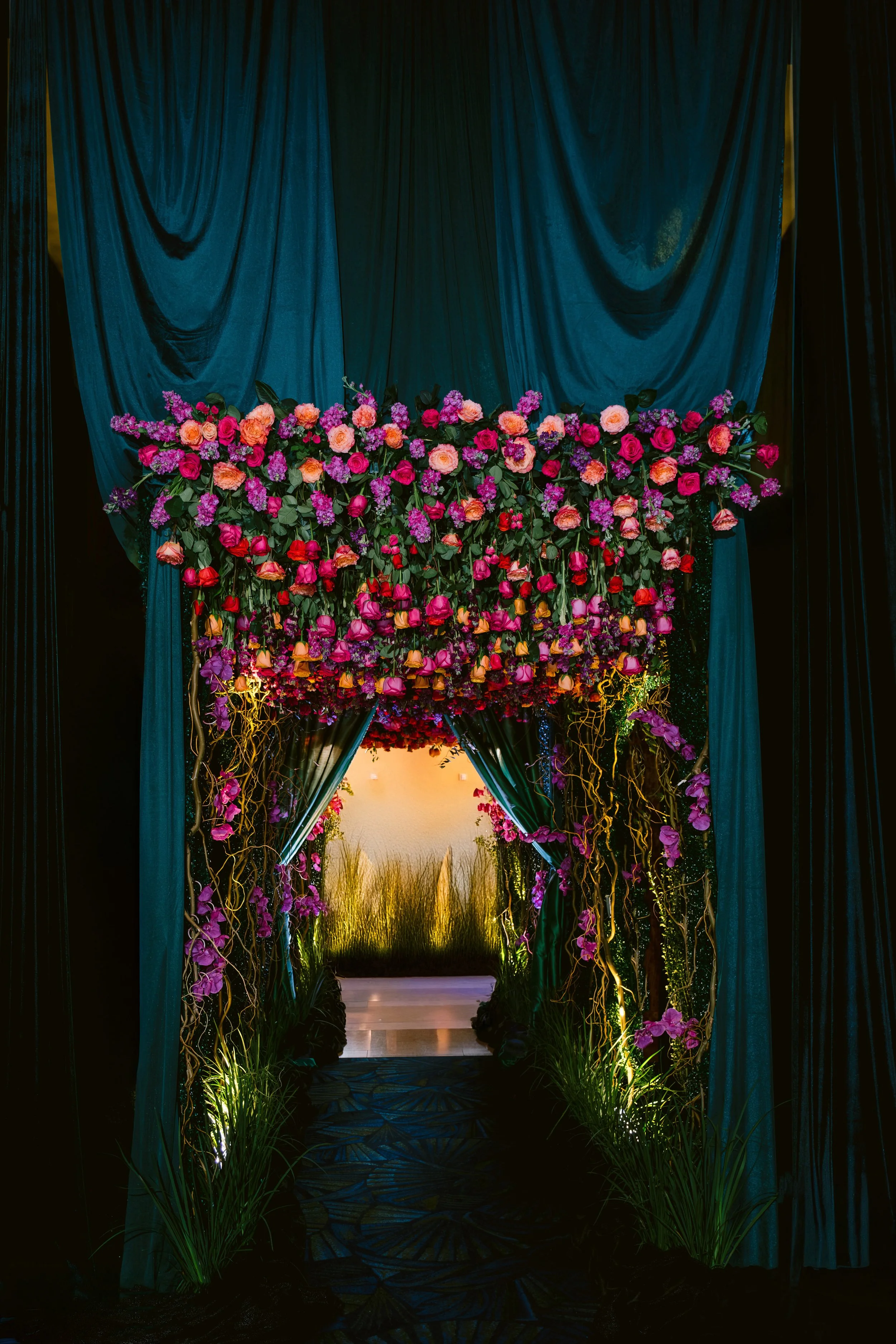 Floral arch framing a draped event entrance
