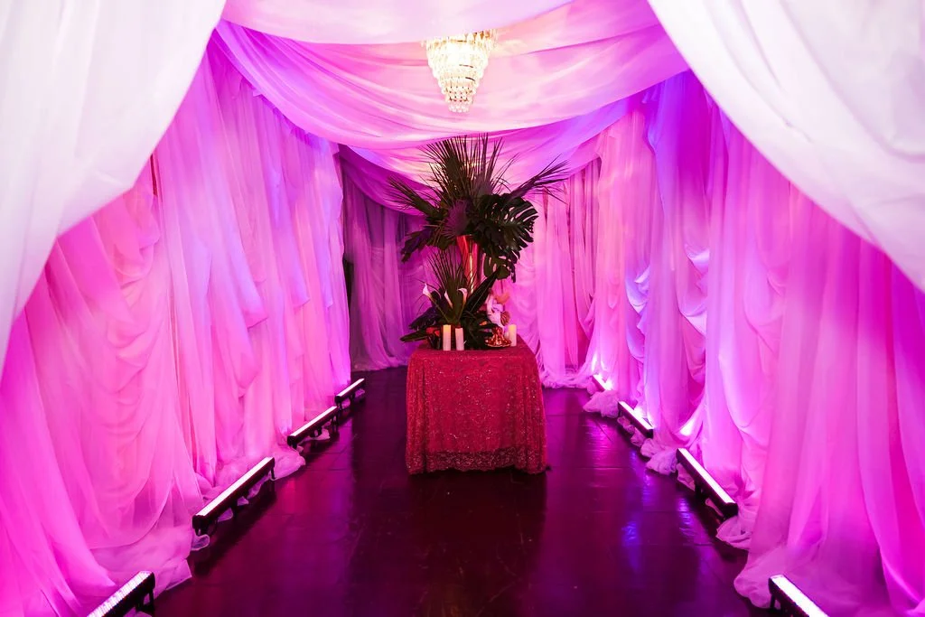 Draped entry corridor washed in warm pink light